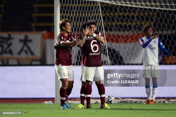 Marquinhos of Vissel Kobe celebrates with his teammates Yuzo Tashiro and Fabio Henrique Simplicio after scoring his team's second goal during the...