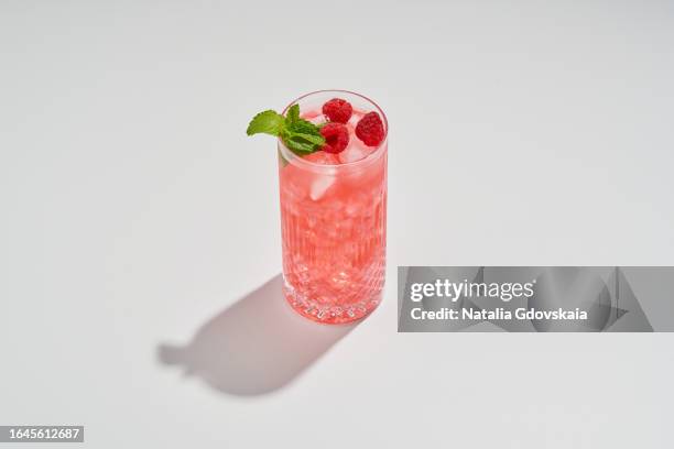 raspberry mojito, refreshing summer drink made with raspberries, mint, lime, and rum. drink serving in glass with ice and garnished sprig of mint - mojito photos et images de collection