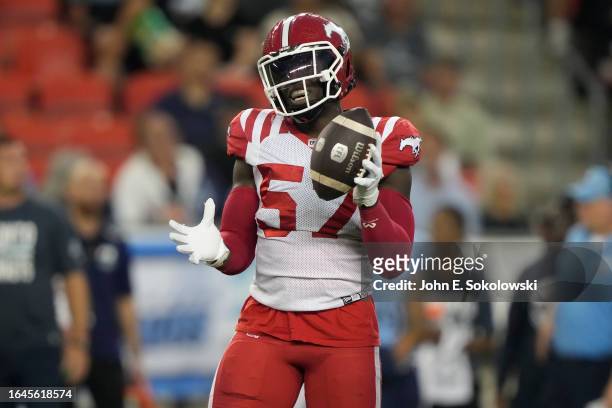 Micah Awe of the Calgary Stampeders holds onto the football after a defensive play against the Toronto Argonauts at BMO Field on August 25, 2023 in...