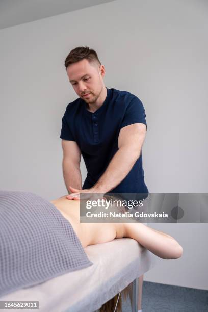 massage therapist masseur massages patient back, relieving tension from muscles and toning up - hernia recovery stock pictures, royalty-free photos & images