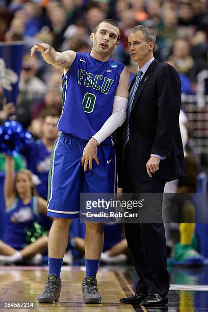 Brett Comer talks with head coach Andy Enfield of the Florida Gulf Coast Eagles in the first half while taking on the San Diego State Aztecs during...