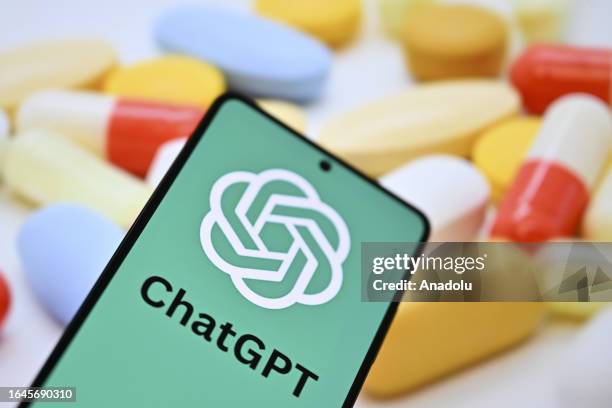 In this photo illustration, ChatGPT logo is being displayed on a mobile phone screen in front of a computer screen displaying pharmaceutical oral...