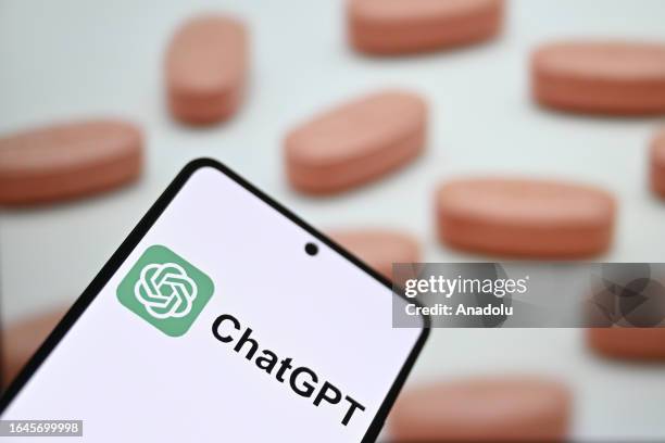 In this photo illustration, ChatGPT logo is being displayed on a mobile phone screen in front of a computer screen displaying pharmaceutical oral...
