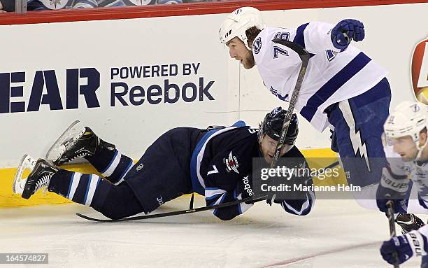 Derek Meech of the Winnipeg Jets gets caught up with Pierre-Cedric Labrie of the Tampa Bay Lightning during first period action in a matchup between...