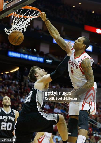 Greg Smith of the Houston Rockets dunks over Tiago Splitter of the San Antonio Spurs at Toyota Center on March 24, 2013 in Houston, Texas. NOTE TO...