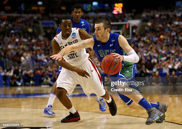 Brett Comer of the Florida Gulf Coast Eagles drives on Xavier Thames of the San Diego State Aztecs in the second half during the third round of the...