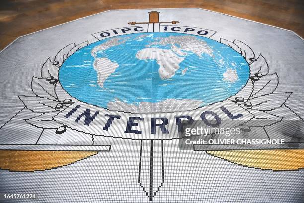 This photograph taken in Lyon, eastern France, on September 5, 2023 shows the logo of the International Criminal Police Organization, known as...
