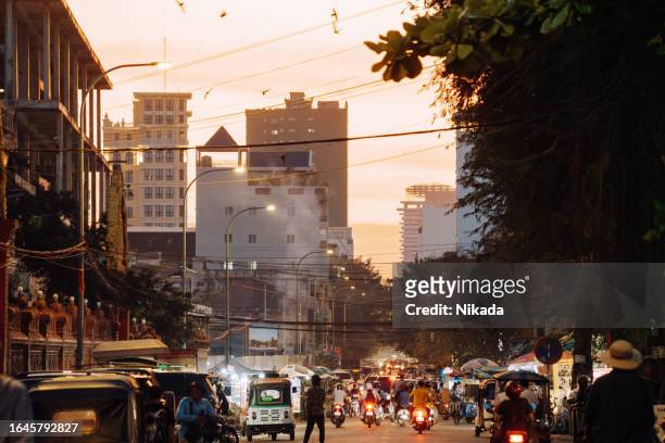 busy street in phnom penh, capital city in cambodia - solar street light stock pictures, royalty-free photos & images