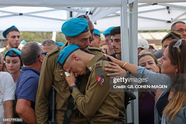 An Israeli soldier is consoled during the funeral of a fellow soldier Maksym Molchanov in Tel Aviv on September 5, 2023. A Palestinian rammed a truck...