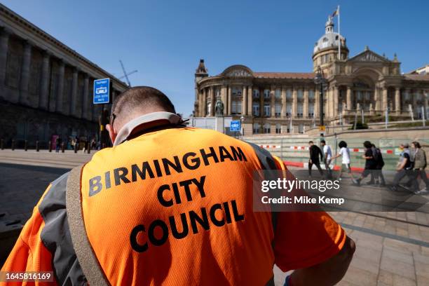 Birmingham City Council refuse collector works emptying the bins opposite the Town Hall building in Victoria Square in the city centre on the day the...