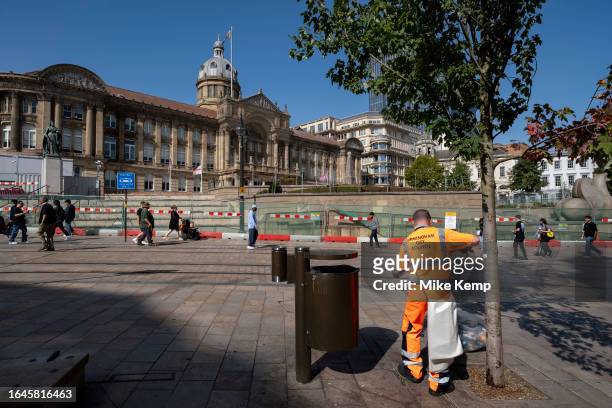 Birmingham City Council refuse collector works emptying the bins opposite the Town Hall building in Victoria Square in the city centre on the day the...