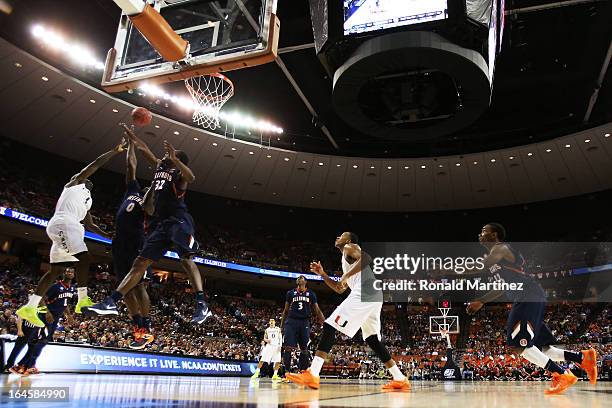 Durand Scott of the Miami Hurricanes goes up against Sam McLaurin and Nnanna Egwu of the Illinois Fighting Illini in the second half during the third...