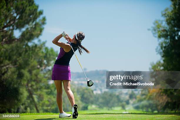 golfschwung - woman swinging at golf course stock-fotos und bilder
