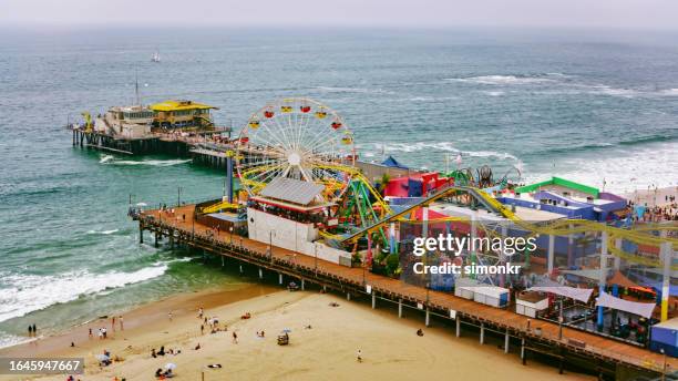 leute, die am santa monica pier genießen - santa monica pier stock-fotos und bilder