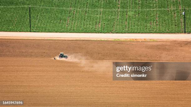 tractor ploughing field - plowed field stock pictures, royalty-free photos & images