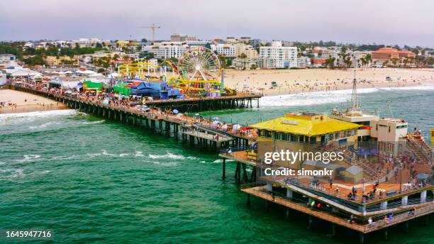 leute, die am santa monica pier genießen - santa monica pier stock-fotos und bilder