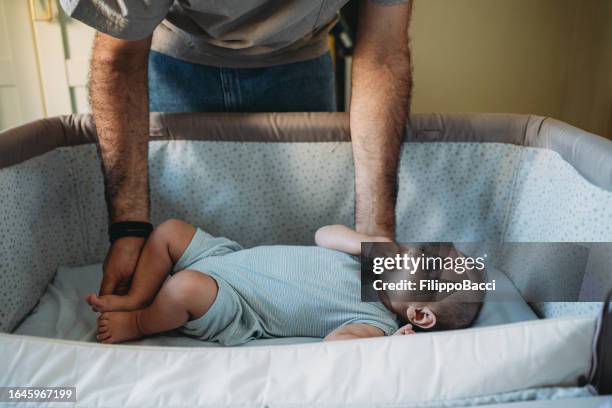 a father is putting his child to sleep - babysäng bildbanksfoton och bilder