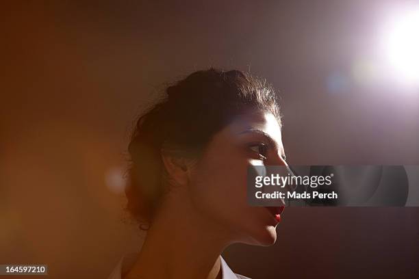 Girl in studio with flare of light behind her