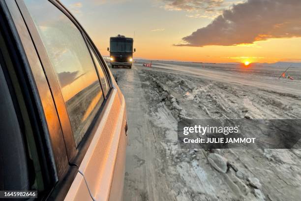 Vehicles line up to leave the site of the annual Burning Man Festival on September 5 after heavy rains turned the site in Nevada's Black Rock desert...