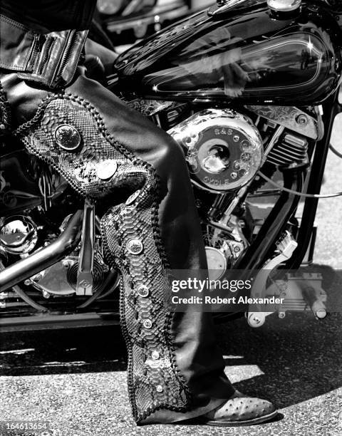 Motorcycle rider wearing black leather and snake skin chaps sits on his motorcycle on Main Street in Daytona Beach, Florida, during the city's annual...