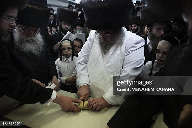 The Belz rabbi cuts the dough before baking the matzoth or unleavened bread for the Pesach holiday in Jerusalem on March 25, 2013. Religious Jews...