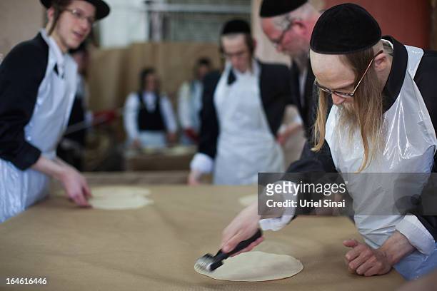 Ultra-Orthodox Jewish men prepare Matzoth, or unleavened bread, in a final preparation before the start at sundown of the Jewish Pesach holiday on...