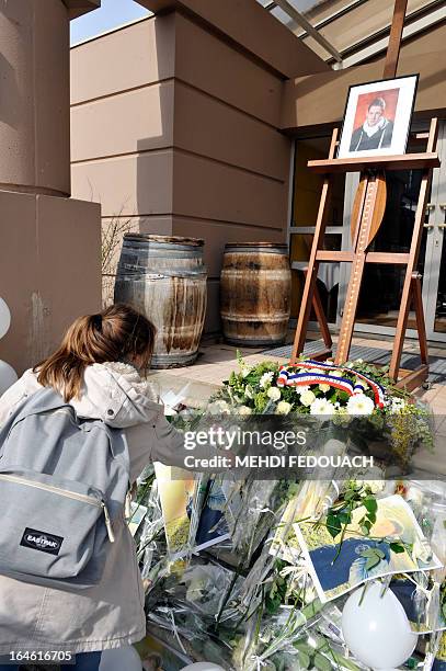 Girl lays a flower on March 25, 2013 in front of a portrait of Sylvain, a 15-year-old schoolboy stabbed on March 19 by a 19-year-old comrade in a...