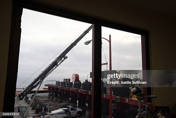 Workers use a crane to lower a new LED sign onto the top of the Golden Gate Bridge toll plaza on March 25, 2013 in San Francisco, California. Workers...