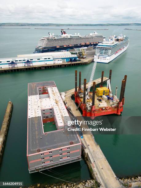 An aerial view of the Bibby Stockholm immigration barge, after the arrival of cruise ships Mein Schiff 3 and Vista, moored in Portland Port, on...