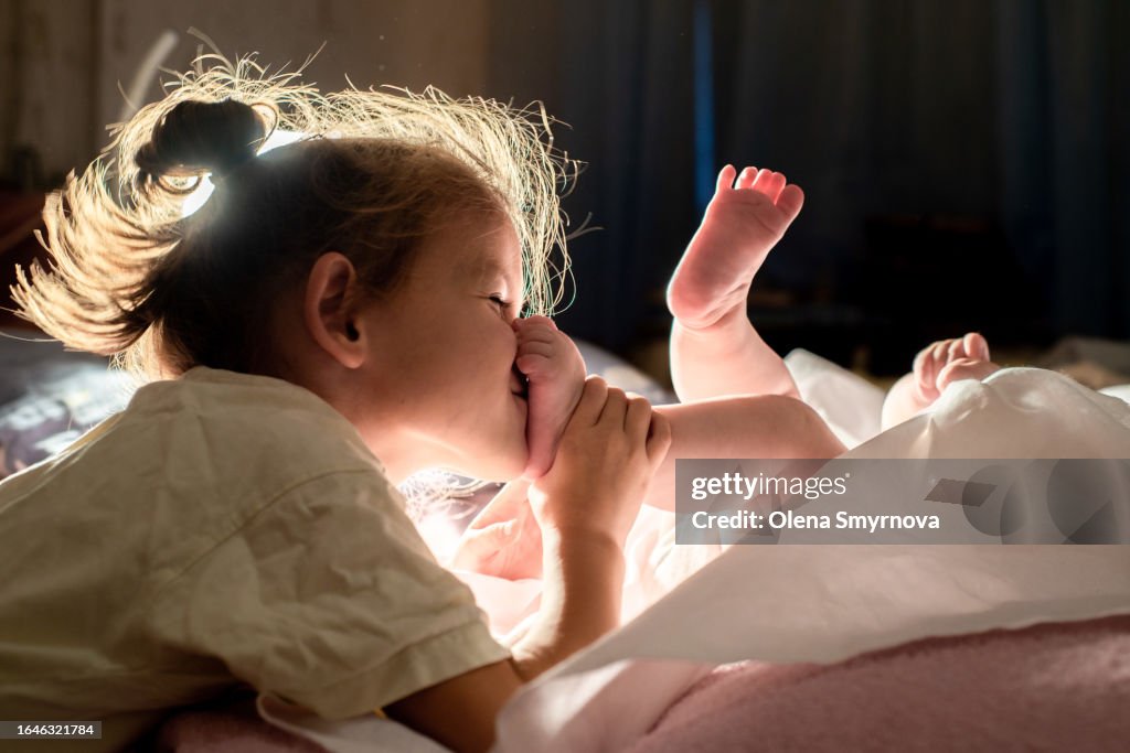 Kid Kisses And Tickles The Heels Of His Younger Brother Or Sister High kid-kisses-and-tickles-the-heels-of-his-younger-brother-or-sister-high