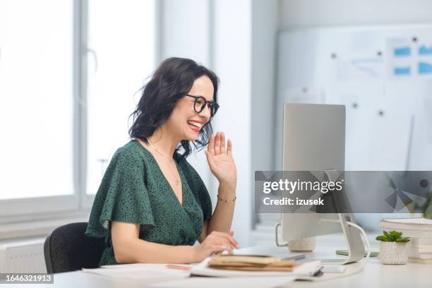 mature woman during video call in the office - waving stock pictures, royalty-free photos & images