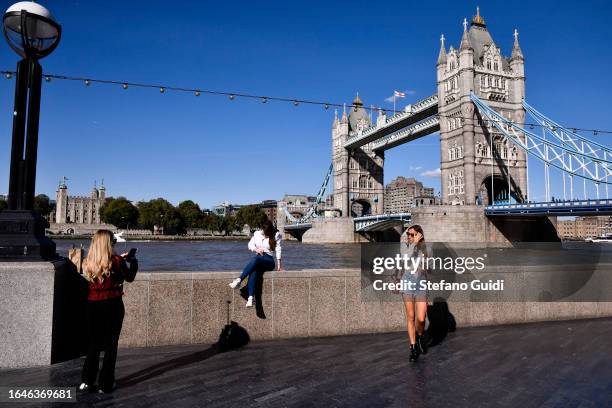 Tourists take selfies in front of Tower Bridge on August 22, 2023 in London, England. London is the capital of England, many of the inhabitants,...