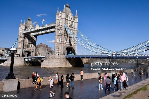 General view of tourists walk on the Queens Walk in front of Tower Bridge on August 22, 2023 in London, England. London is the capital of England,...