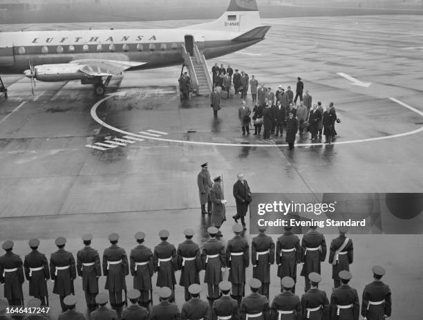 Aerial view of West German Chancellor Konrad Adenauer inspecting a guard of honour after arriving in London for an official visit in February 1960.