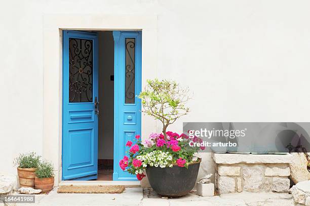 blue door and flower pots with cushion bench facade croatia - blue house red door stock pictures, royalty-free photos & images