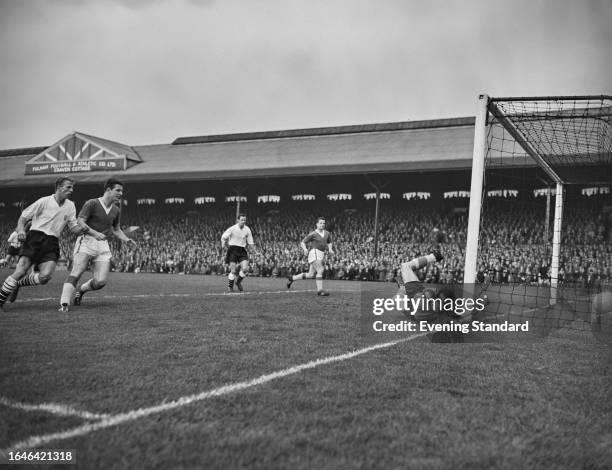 Everton goalkeeper Albert Dunlop stretches to make a save as Everton's Brian Labone and Fulham's Maurice Cook look on during a match at Craven...