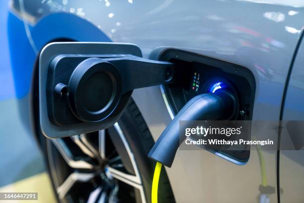 close-up hand grip plug of industrial electric charging machine - elektrische auto stockfoto's en -beelden