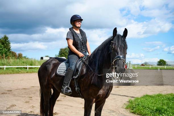 woman trains her horse on the riding track - riding hat stock pictures, royalty-free photos & images