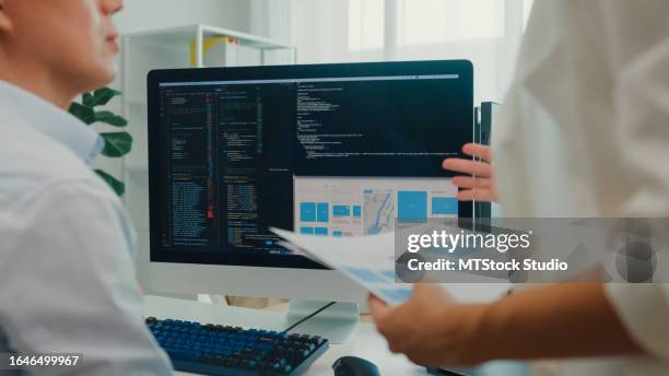 closeup group of asian people software developers using computer to write code sitting at desk with multiple screens at office. programmer development. - software programmer stock pictures, royalty-free photos & images
