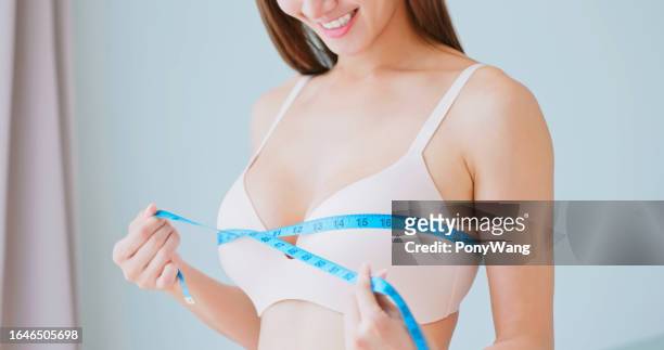 mujer mide el tamaño del pecho corporal - sostén fotografías e imágenes de stock