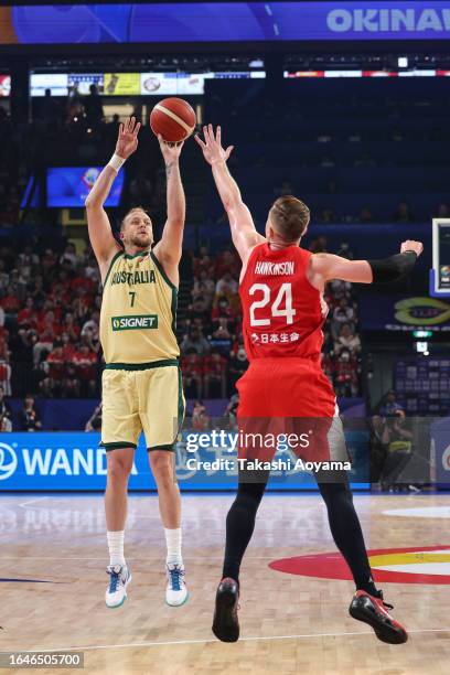 Joe Ingles of Australia shoots a three point shot under pressure from Joshua Hawkinson of Japan during the FIBA Basketball World Cup Group E game...