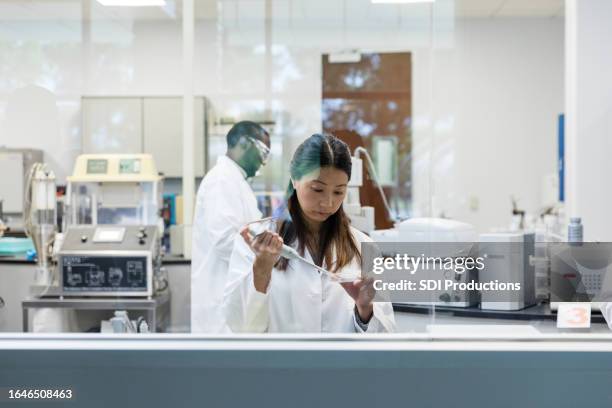 diverse technicians are seen conducting experiments in the lab - scientific research stock pictures, royalty-free photos & images