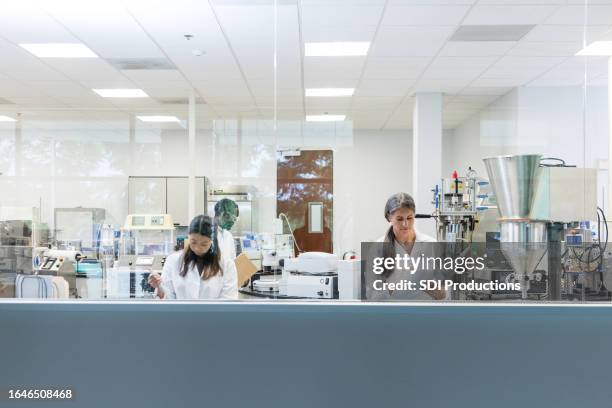 gemischtrassige gruppe von wissenschaftlern führt hochmoderne experimente im labor durch - wissenschaftliche forschung stock-fotos und bilder