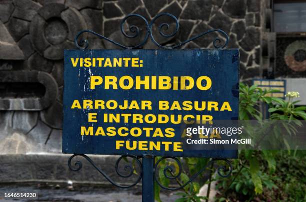 spanish-language sign stating 'visitante: prohibido arrojar basura e introducir mascotas a la fuente' [visitor: littering and bringing pets into the fountain is prohibited] - prohibido stock pictures, royalty-free photos & images