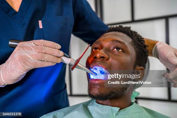 dentist repairing patient teeth in the dentist's clinic - dental calculus stock pictures, royalty-free photos & images