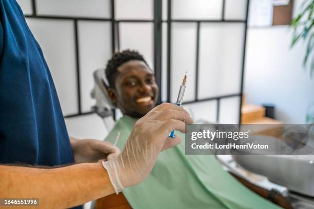 dentist giving anesthesia to a male patient - plaque remover stock pictures, royalty-free photos & images