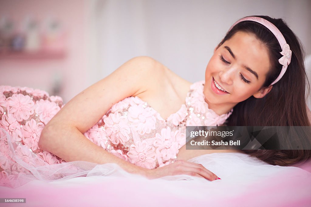 Girl Lying Down on Bed In Pink Floral Dress