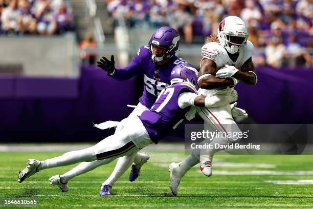 Corey Clement of the Arizona Cardinals is tackled by Kalon Barnes while Andre Carter II of the Minnesota Vikings defends in the second half of a...