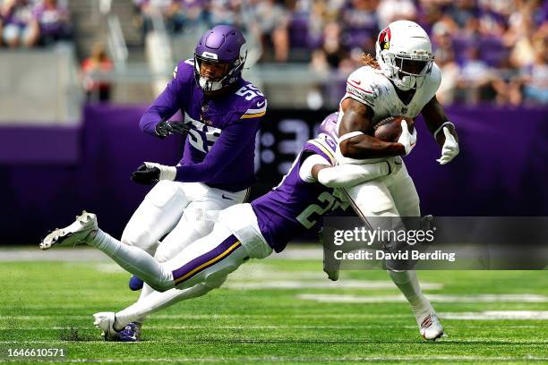 Corey Clement of the Arizona Cardinals is tackled by Kalon Barnes while Andre Carter II of the Minnesota Vikings defends in the second half of a...