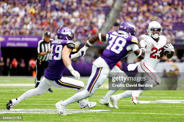 Corey Clement of the Arizona Cardinals runs with the ball while Jake Gervase and Jaylin Williams of the Minnesota Vikings defend in the second half...